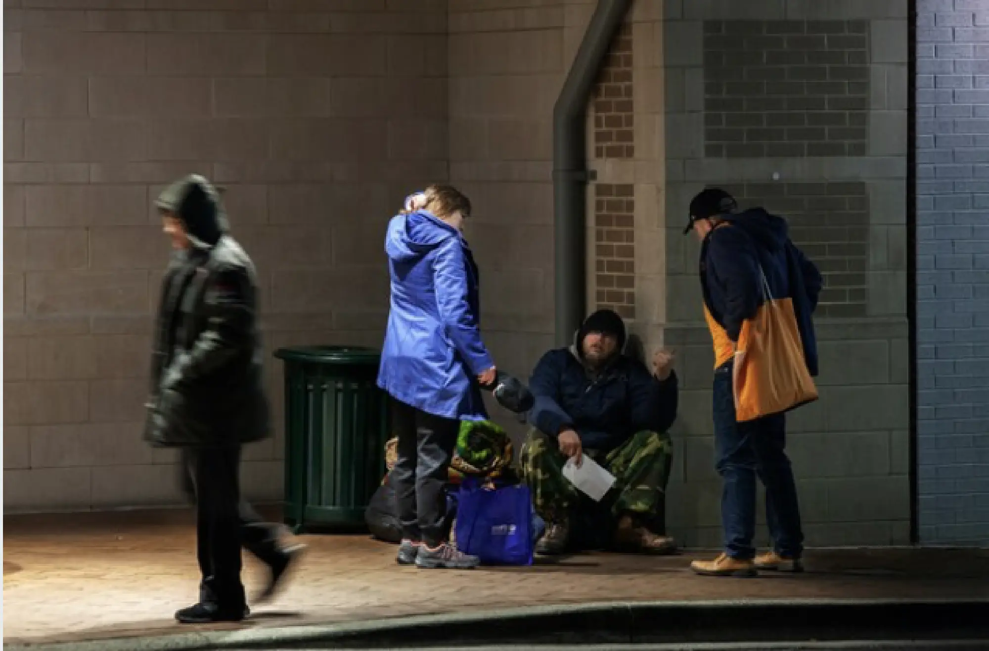 Gabriel Santos and Deborah Taylor, of the outreach organization Bethesda Cares, talk with a homeless person about the coronavirus on March 17, 2020, in Silver Spring, Md. MUST CREDIT: Photo for The Washington Post by by Robb Hill