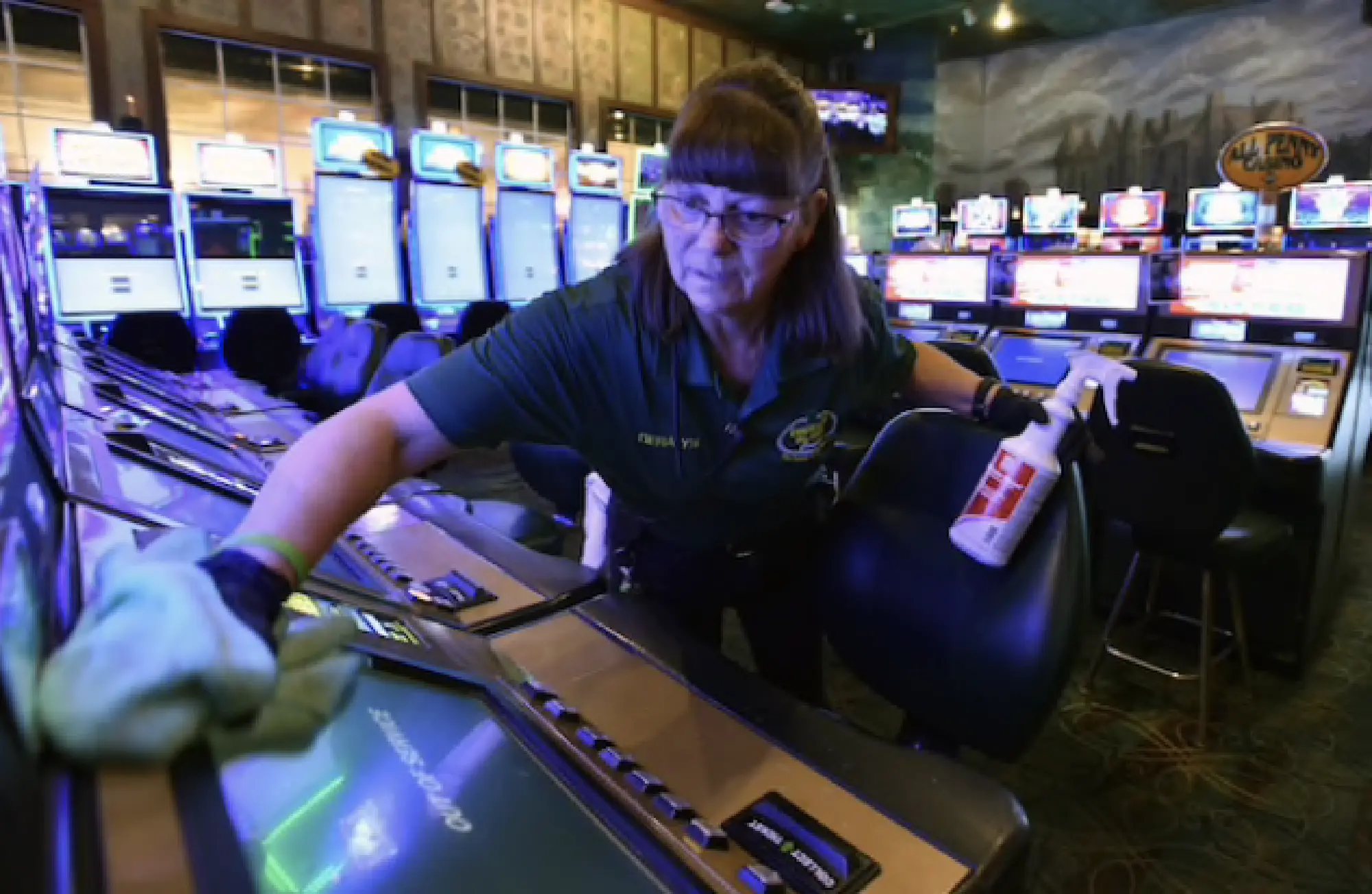 Casino porter Geralyn Johnson deep-cleans video poker machines inside the now-closed Emerald Island Casino in Henderson, Nev. MUST CREDIT: Photo by David Becker for The Washington Post