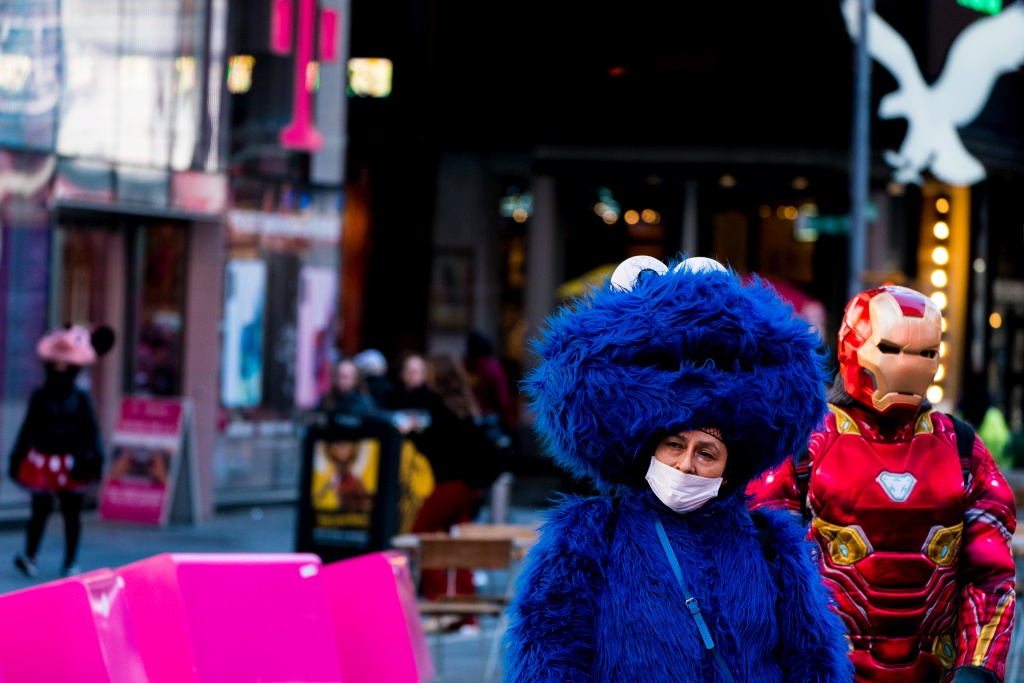 A costumed street performer gets some air while wearing a mask in Times Square on March 14. MUST CREDIT: Photo byJeennah Moon for The Washington Post