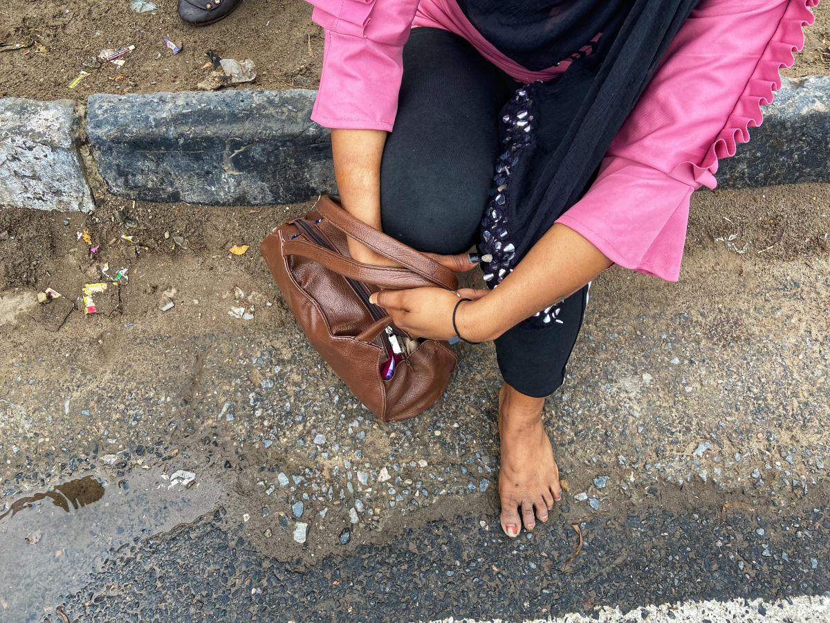Payal Kumar, 19, is barefoot on a Delhi road after her sandals broke from a seven-hour walk. She and her family are shown March 27, 2020, as they were walking to their village 150 miles away. PHOTO CREDIT: Washington Post photo by Niha Masih