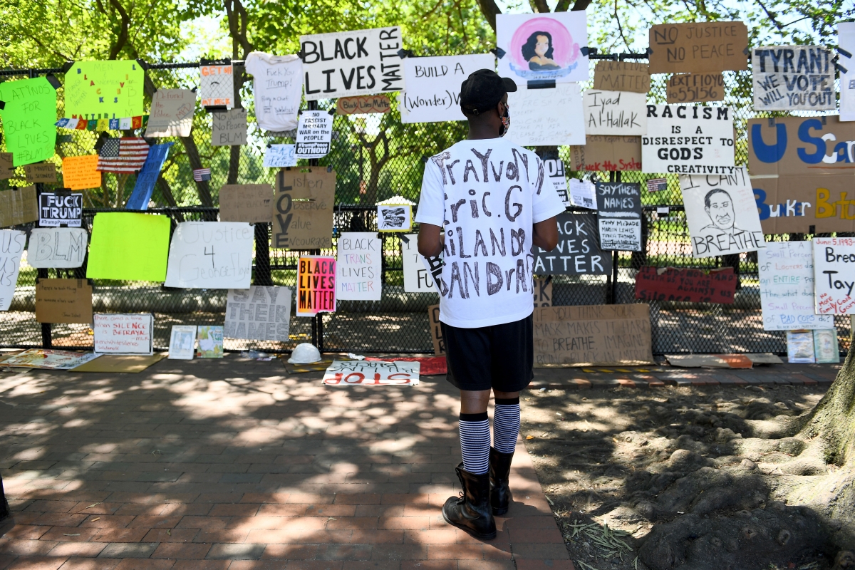 Latif Schofield surveys protest signs and artwork at the fence surrounding the White House on Sunday, June 7, 2020. MUST CREDIT: Washington Post photo by Katherine Frey