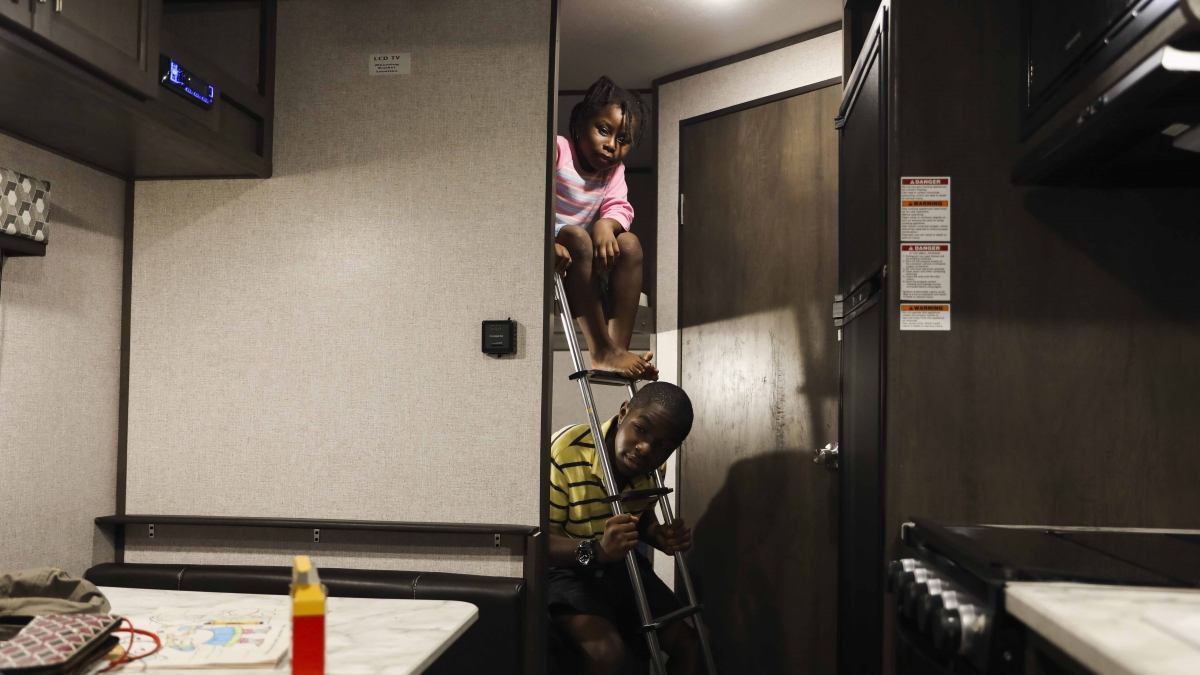 Jayden, 12, and Phoenix, 7, sit on their new beds in their family's new RV on June 7. This is the first time since March that the siblings have their own separate beds to sleep in. MUST CREDIT: Photo by Eve Edelheit for The Washington Post.