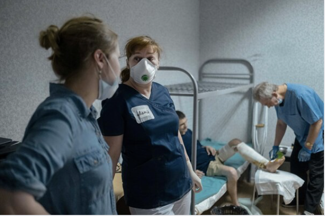 Lana Zhurkina, right, talks to a social worker while providing a medical help for a men living in one of the hostels organized by Dom Druzei (House of Friends) in Moscow on June 24, 2020. MUST CREDIT: Photo for The Washington Po