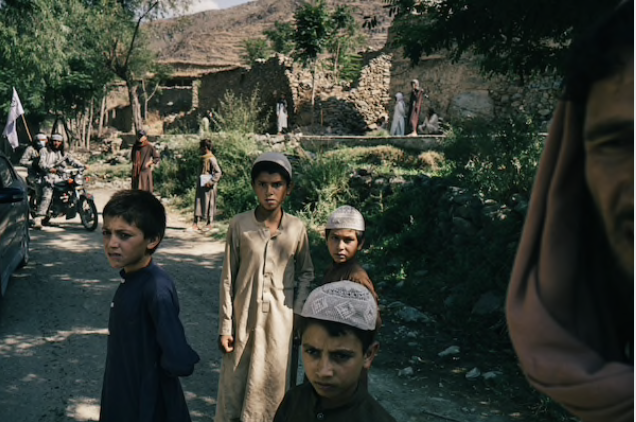 Children look at a group of Taliban fighters parading their weapons in Marawara district, Afghanistan, on July 6, 2020. MUST CREDIT: Photo for The Washington Post by Lorenzo Tugnoli