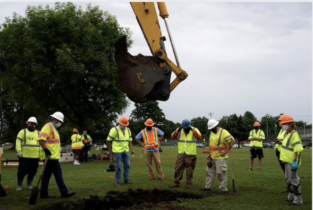 Archaeologists and forensic scientists watch as excavation begins at Tulsa's Oaklawn Cemetery, where there could be a mass grave from the 1921 race massacre. MUST CREDIT: Photo by Nick Oxford for The Washington Post.