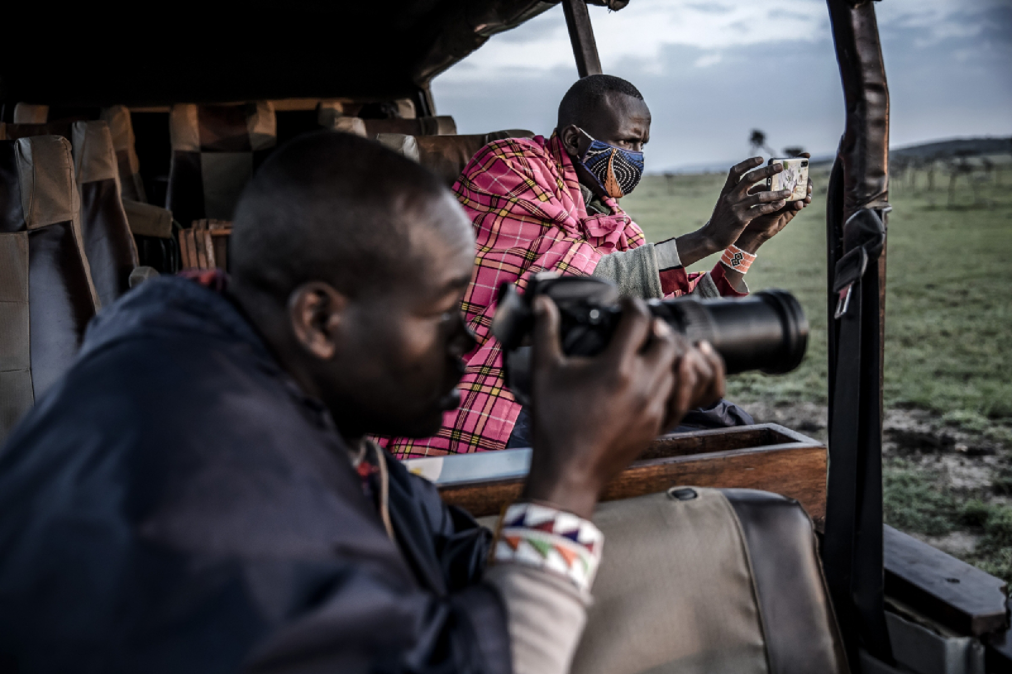 Ben Tongoyo, a Maasai safari guide working with Ol Kinyei Conservancy, takes pictures and videos of a lion with his phone to be used for virtual safaris. MUST CREDIT: Photo for The Washington Post by Luis Tato