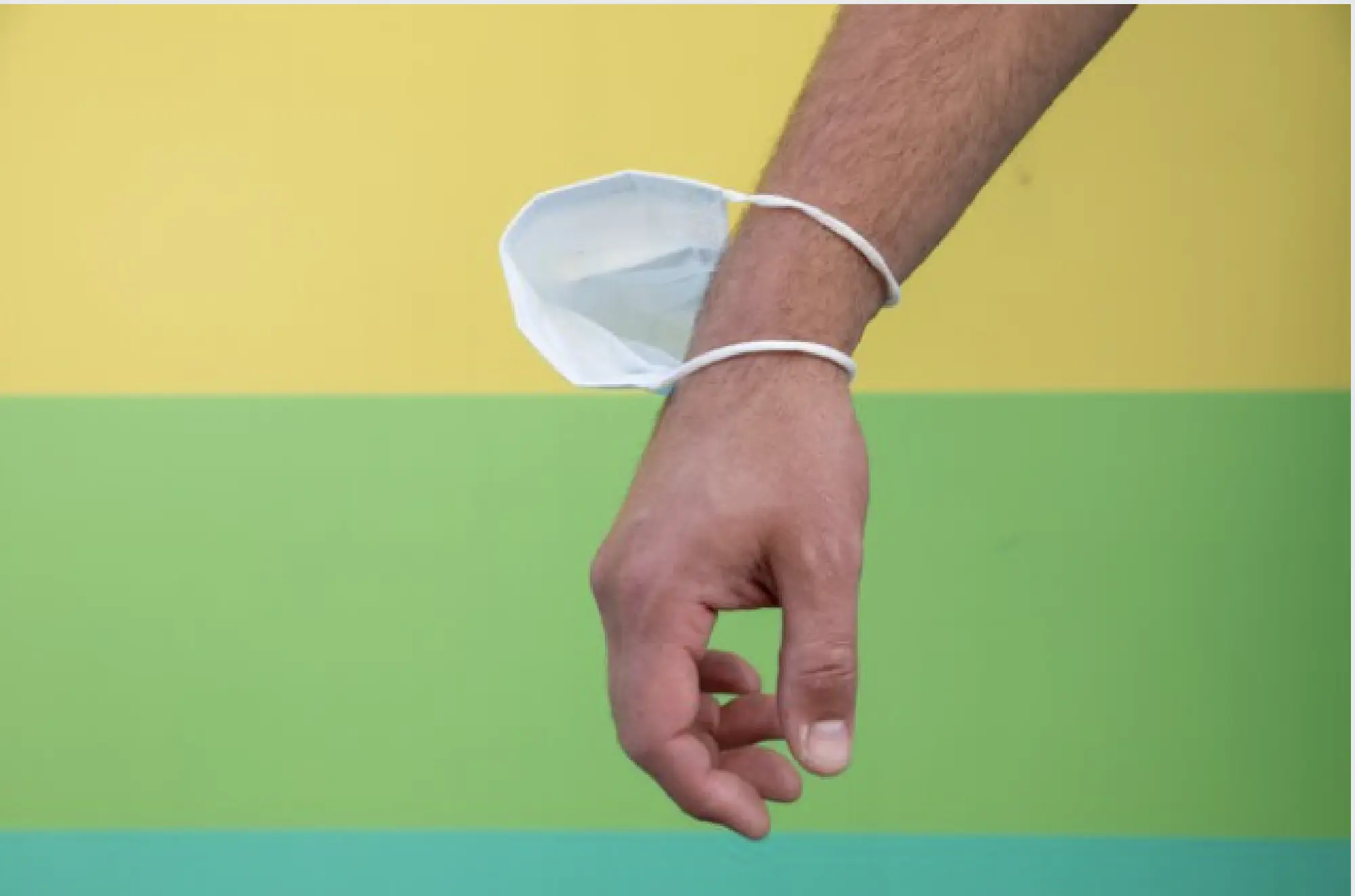 A man wears a mask around his wrist while walking in Washington last week. He said he didn't like wearing his mask because he recently had open heart surgery and is still experiencing breathing problems. MUST CREDIT: Photo by Amanda Andrade-Rhoades for The Washington Post.