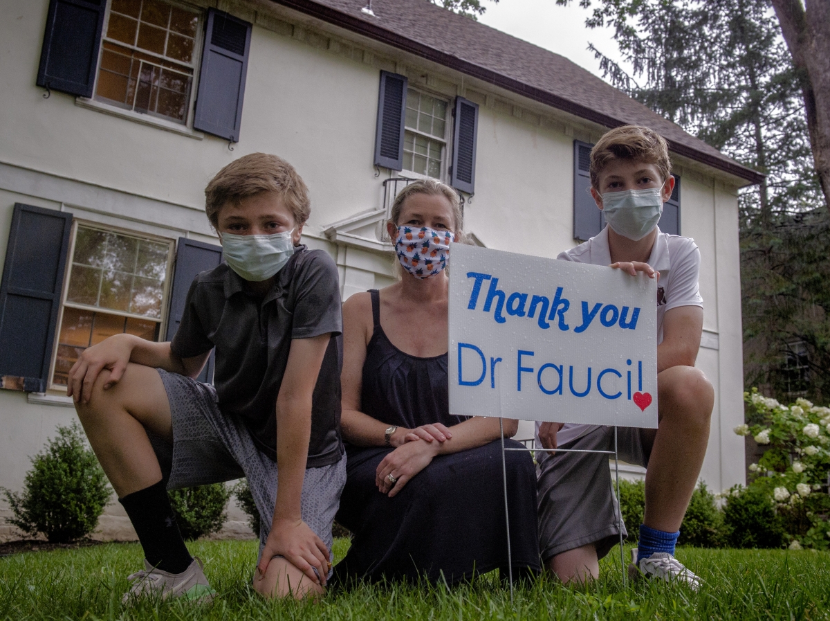 Ida Bergstrom and her sons Lars, 11, left, and Nils, 14, are selling yard signs to show support for Anthony Fauci, who is the nation's top infectious-disease expert and one of their neighbors. MUST CREDIT: Washington Post photo by Bill O'Leary.