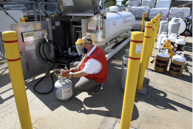 Tim Linch fills a propane tank for a customer at Tractor Supply. CREDIT: Washington Post photo by Katherine Frey.