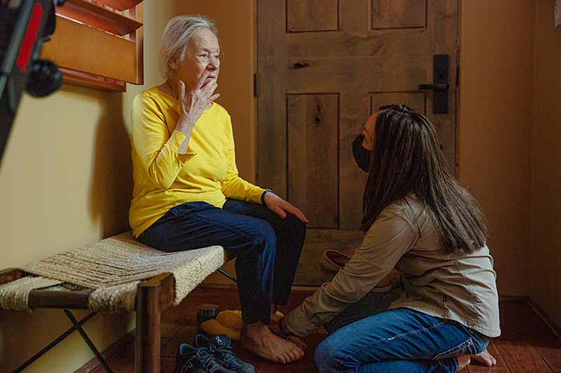 Dena helps Rhoda put on her shoes before a walk. MUST CREDIT: Photo by Mary Mathis for The Washington Post.