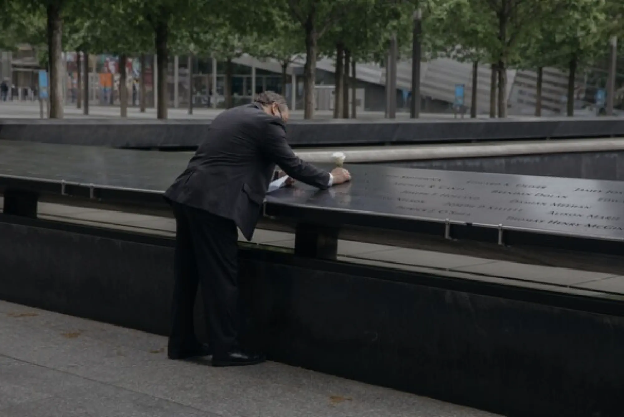 Eddie Mangual, a retired New York City police detective, places a white rose at the National September 11 Memorial Museum. MUST CREDIT: Photo by Celeste Sloman for The Washington Post