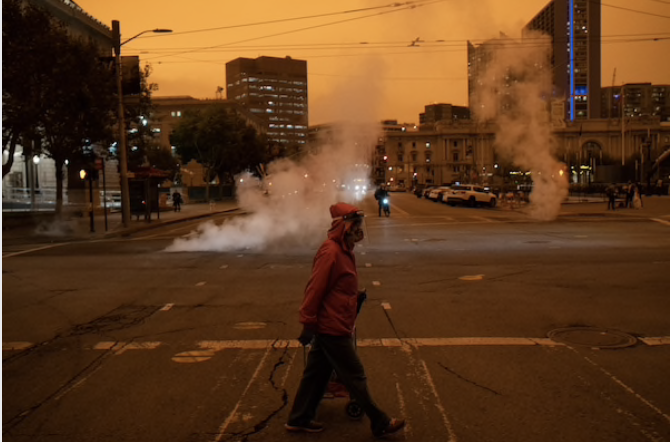 A pedestrian crosses the street near City Hall on Wednesday as San Francisco was blanketed in an eerie haze from the wildfires. CREDIT: Photo by Nick Otto for The Washington Post