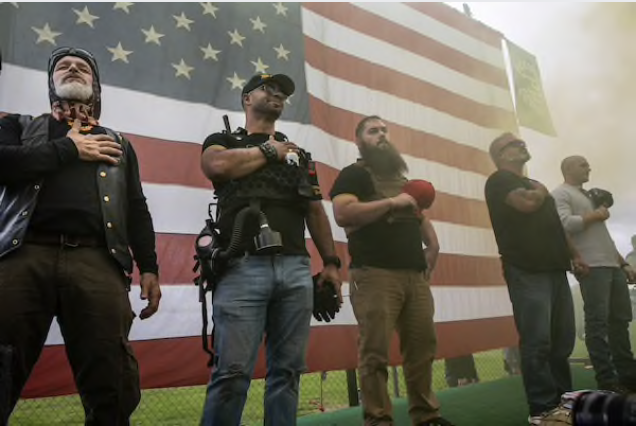 Proud Boys organizers stand on stage during Saturday's event in Portland, Ore. Organizers were expecting as many as 10,000 right-leaning activists to attend.  CREDIT: Photo by Paula Bronstein for The Washington Post