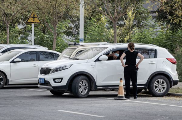 Our departing Beijing bureau chief, Anna Fifield, confronts a driver who had been very obviously following her car around the Kashgar area. CREDIT: Photo by Lorenz Huber for The Washington Post.
