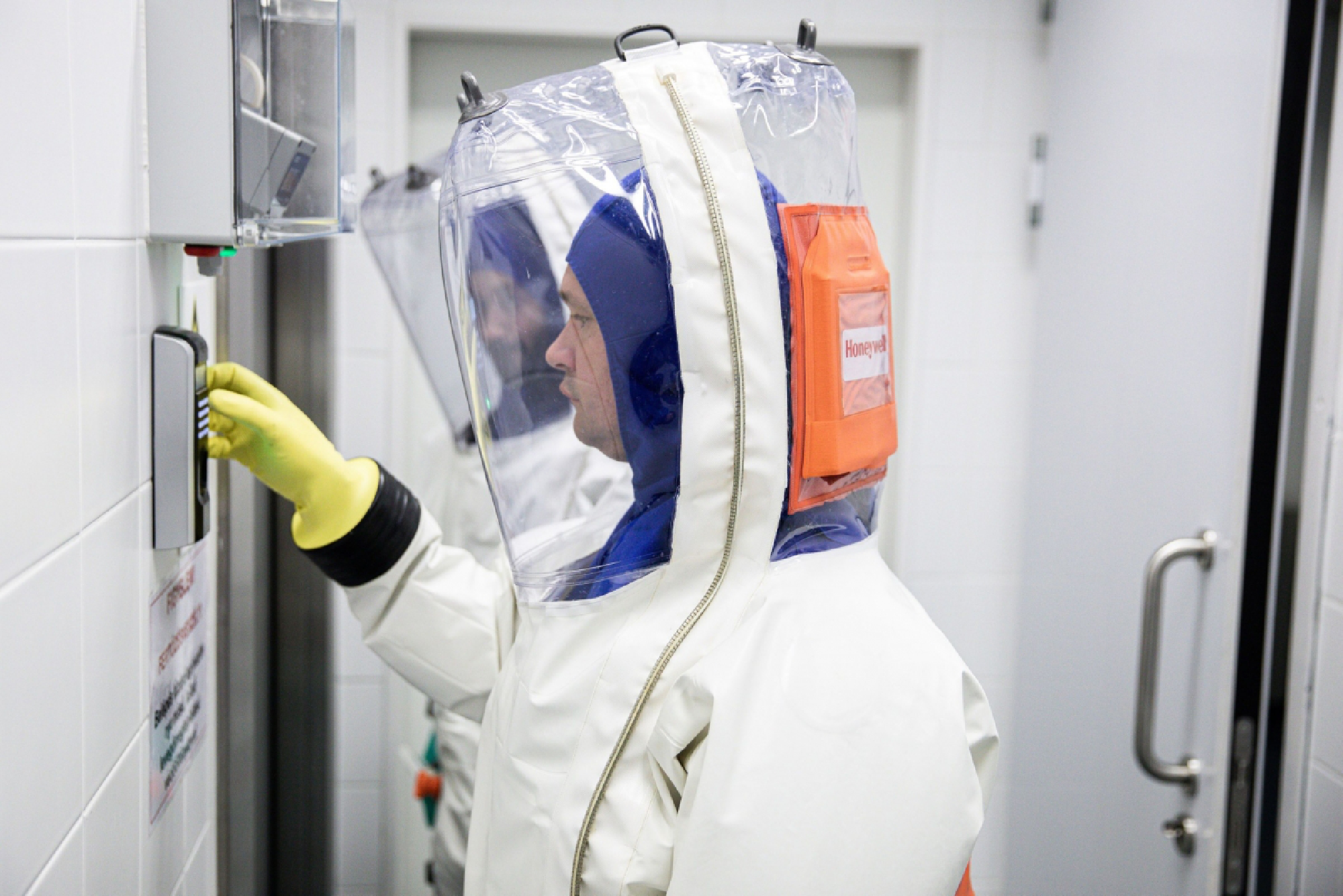 Scientists dressed in a full body protective suits enter a laboratory used for coronavirus research in Pecs, Hungary. MUST CREDIT: Bloomberg photo by Akos Stiller