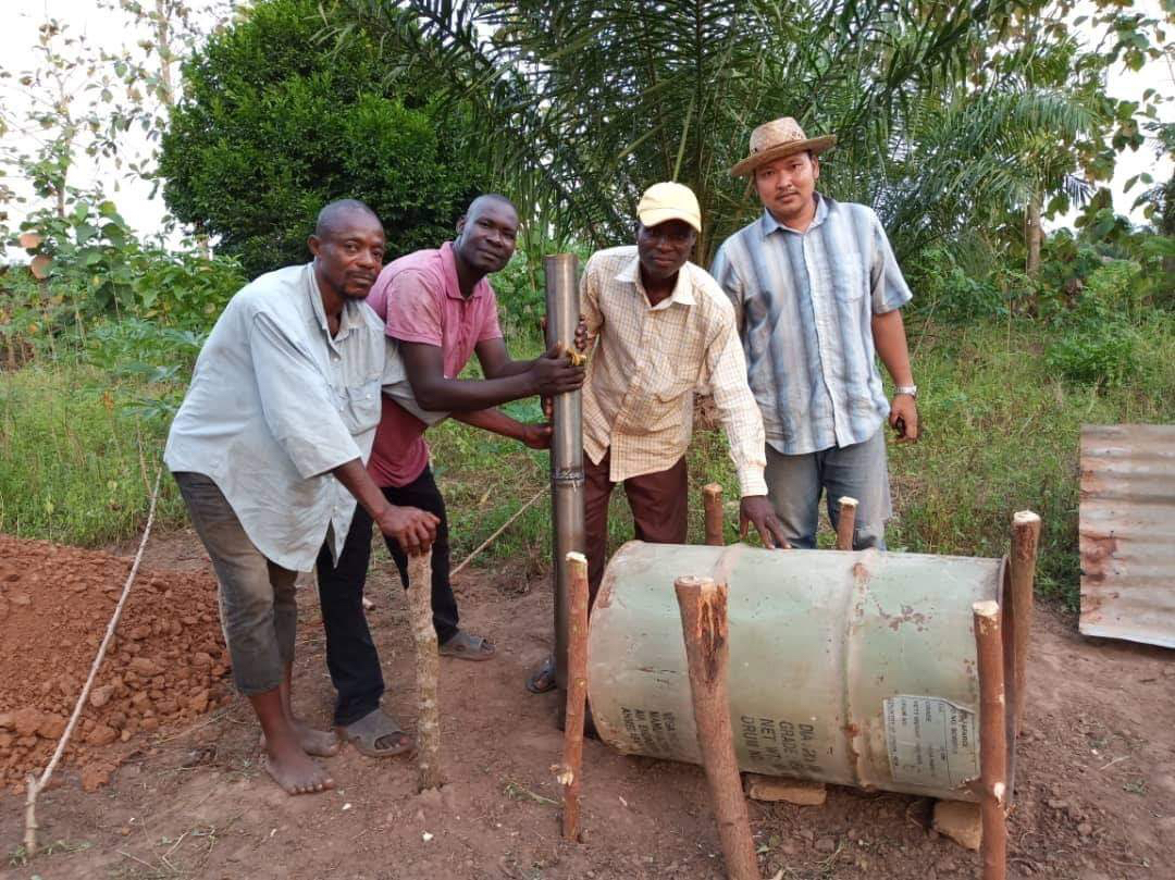 FFT volunteer Phuttiphum Arsanok helps farmers in Djakotomey, a town in Benin, adapt local materials to make equipment for organic fertilizers. 