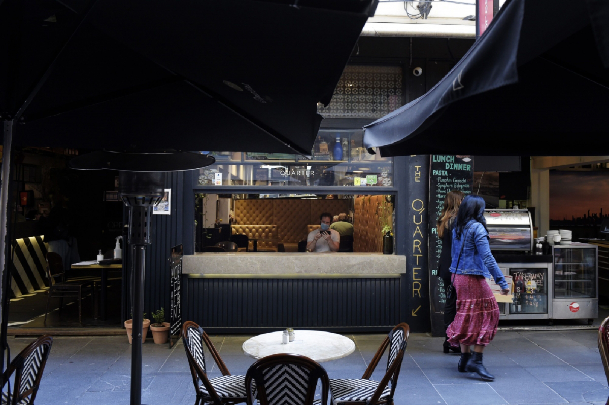 A diner wears a protective mask while sitting inside a restaurant in Melbourne, Australia, on Oct 28, 2020. MUST CREDIT: Bloomberg photo by Carla Gottgens.
