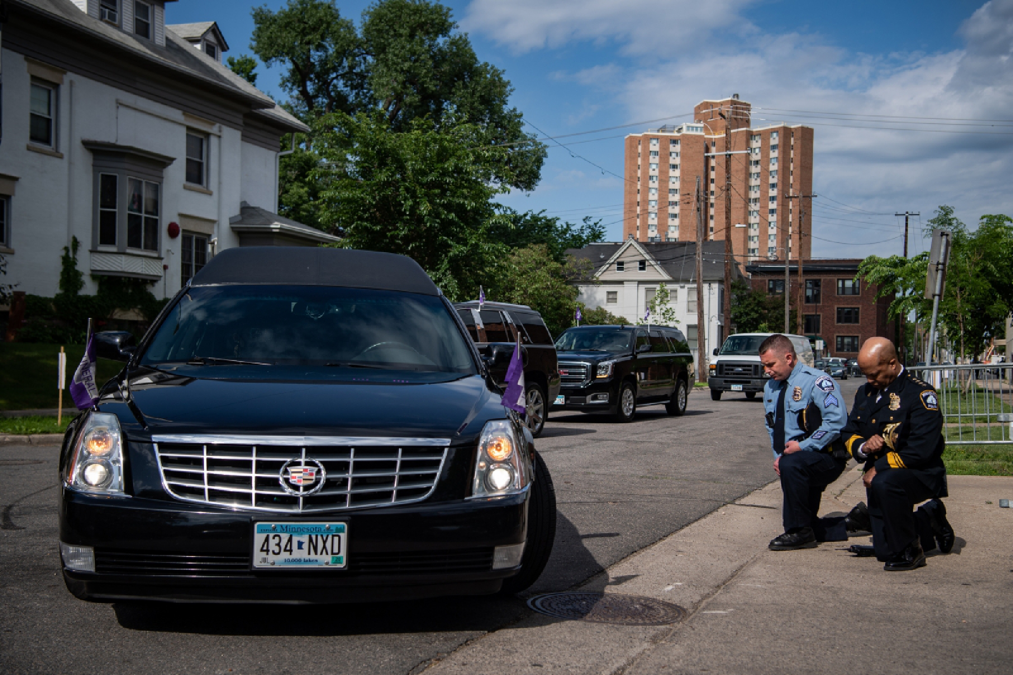 Minneapolis Police Chief Medaria Arradondo, right, kneels as the hearse carrying George Floyd's body arrives at North Central University for a June 4 funeral. MUST CREDIT: Washington Post photo by Salwan Georges