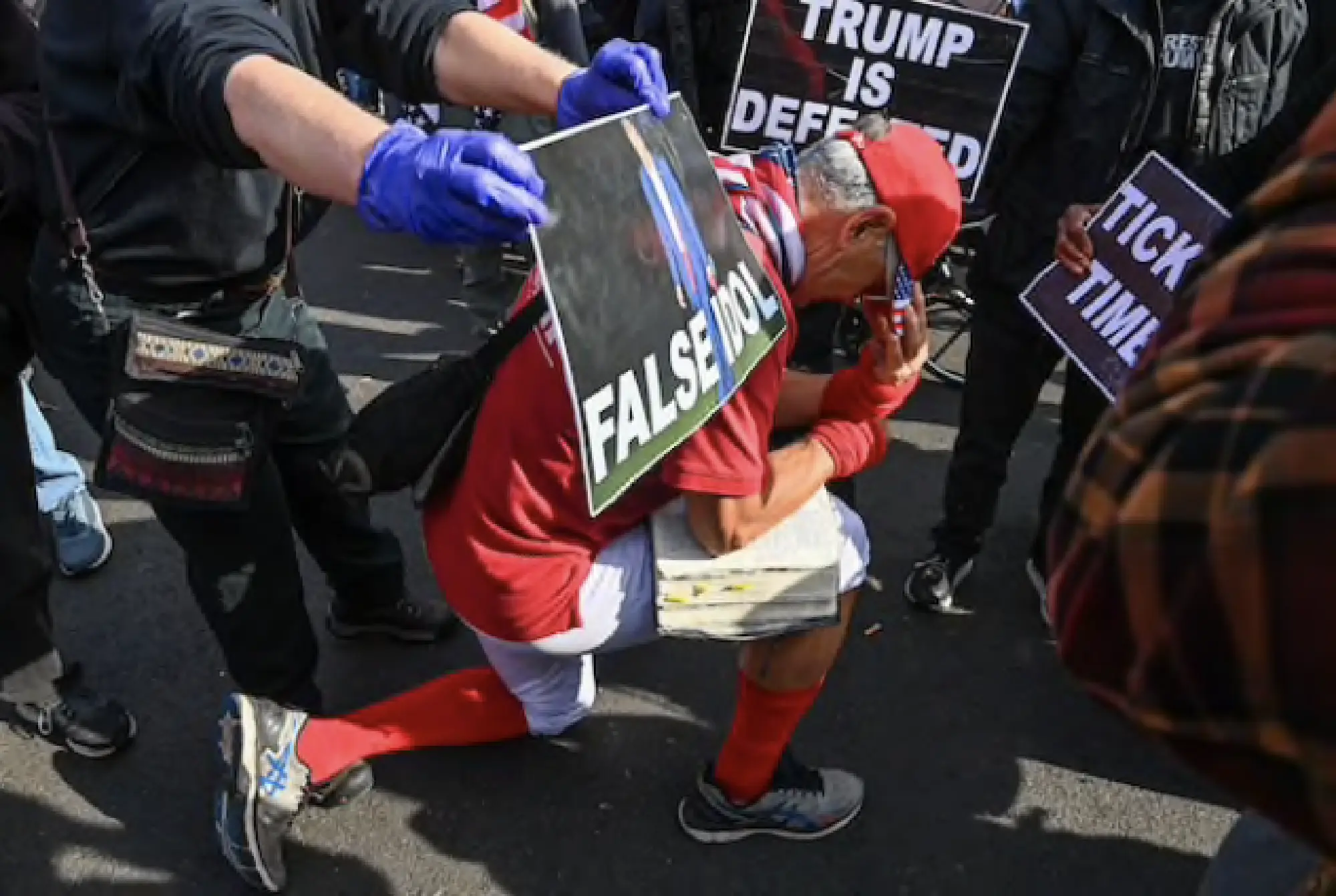A pro-Trump demonstrator kneels to pray above his Bible as he and other supporters square off with anti-Trump demonstrators at Black Lives Matter Plaza on Friday. MUST CREDIT: Washington Post photo by Ricky Carioti