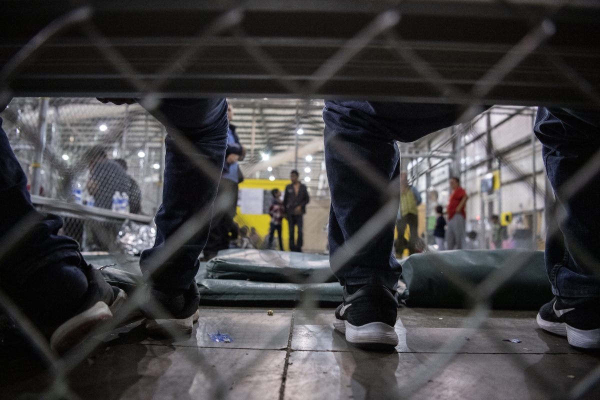 Men sit on a bench with other fathers of young children in the McAllen, Texas, facility. MUST CREDIT: Washington Post photo by Carolyn Van Houten.