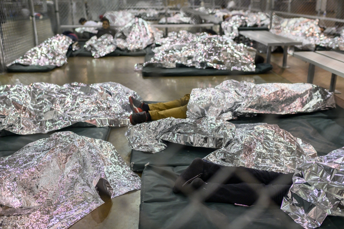 Male minors rest under Mylar blankets in the Border Patrol Central Processing Center in McAllen, Texas., in August 2019. MUST CREDIT: Washington Post photo by Carolyn Van Houten.