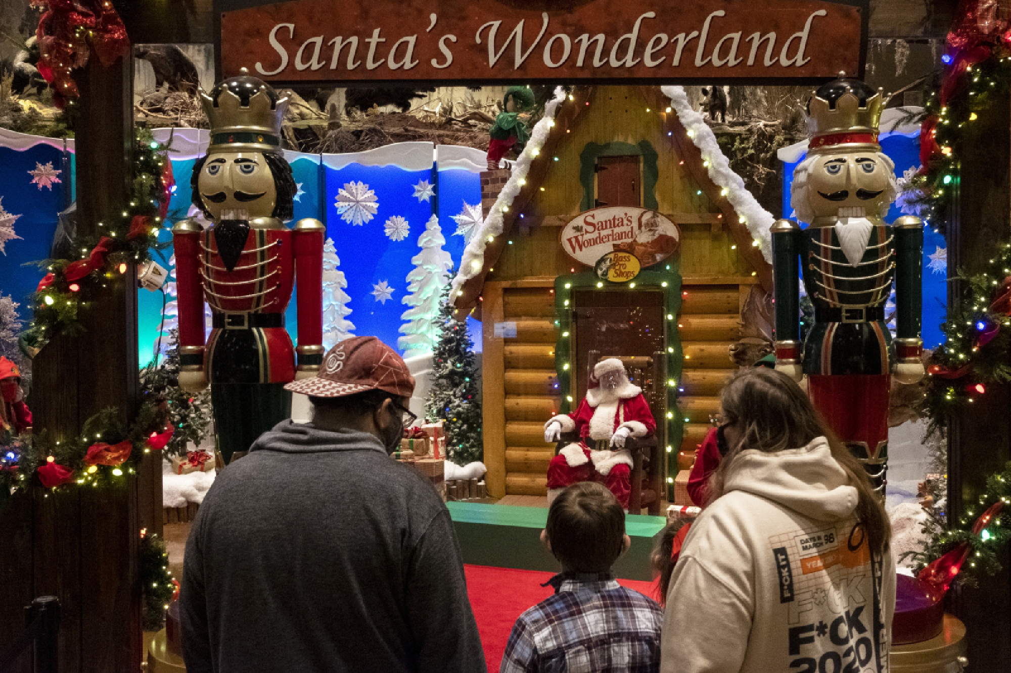 Santa dons a face shield and sits behind plexiglass at a Bass Pro Shops store this week in Springfield, Mo. MUST CREDIT: Washington Post photo by Annaliese Nurnberg.