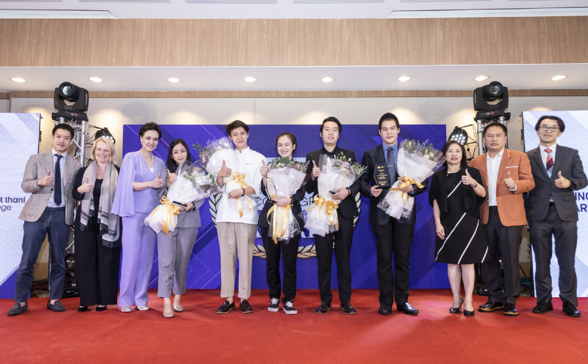 Alumni receive flower bouquet and award from the college to celebrate their success in business and food competition. 