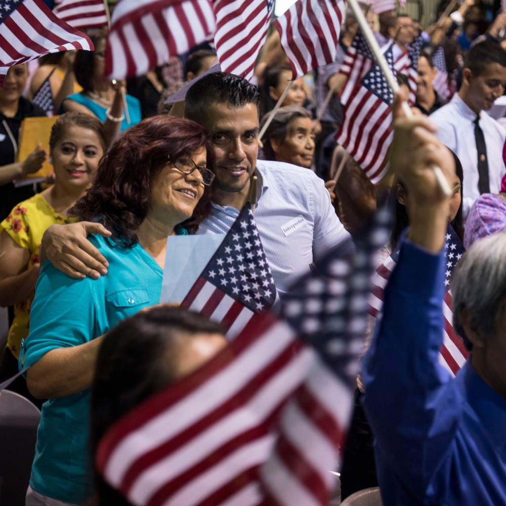 David Reyna hugs his mother, Tina Chavez, originally from Mexico, as she participates in the Fiesta of Independence Naturalization Ceremony at South Mountain Community College in Phoenix on July 4, 2018. MUST CREDIT: Washington Post photo by Carolyn Van Houten.
