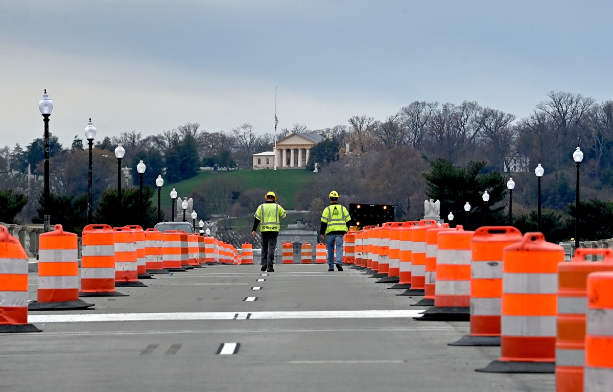 Workers walk the Arlington Memorial Bridge just before it opened to traffic Friday. The bridge over the Potomac River between Washington, D.C., and Arlington, Va., reopened after a two-year, $227 million rehabilitation project that had disrupted traffic on one of Washington's most heavily used and historic spans. MUST CREDIT: Washington Post photo by Michael S. Williamson