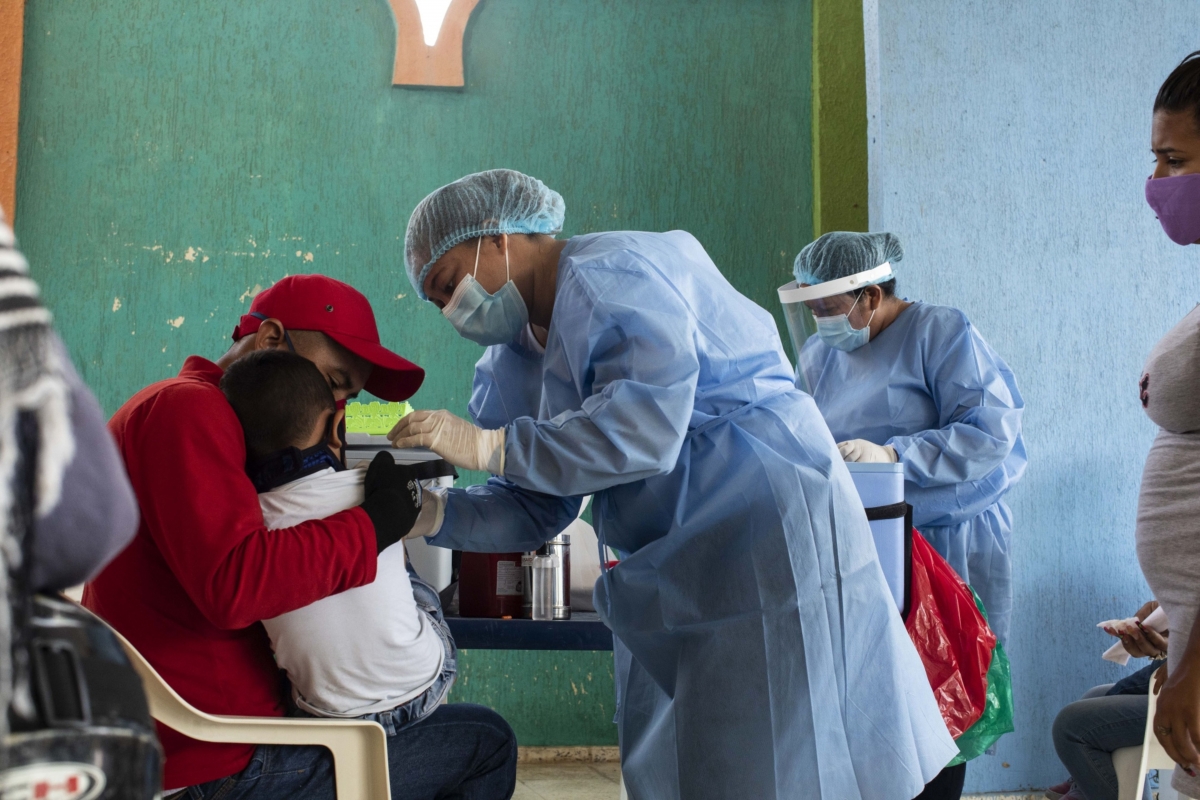 Health-care workers of the San Jose Hospital mobile unit treat Venezuelan migrants at a closed school in Maicao, La Guajira, Colombia, on Oct. 1, 2020. MUST CREDIT: Bloomberg photo by Nicolo Filippo Rosso