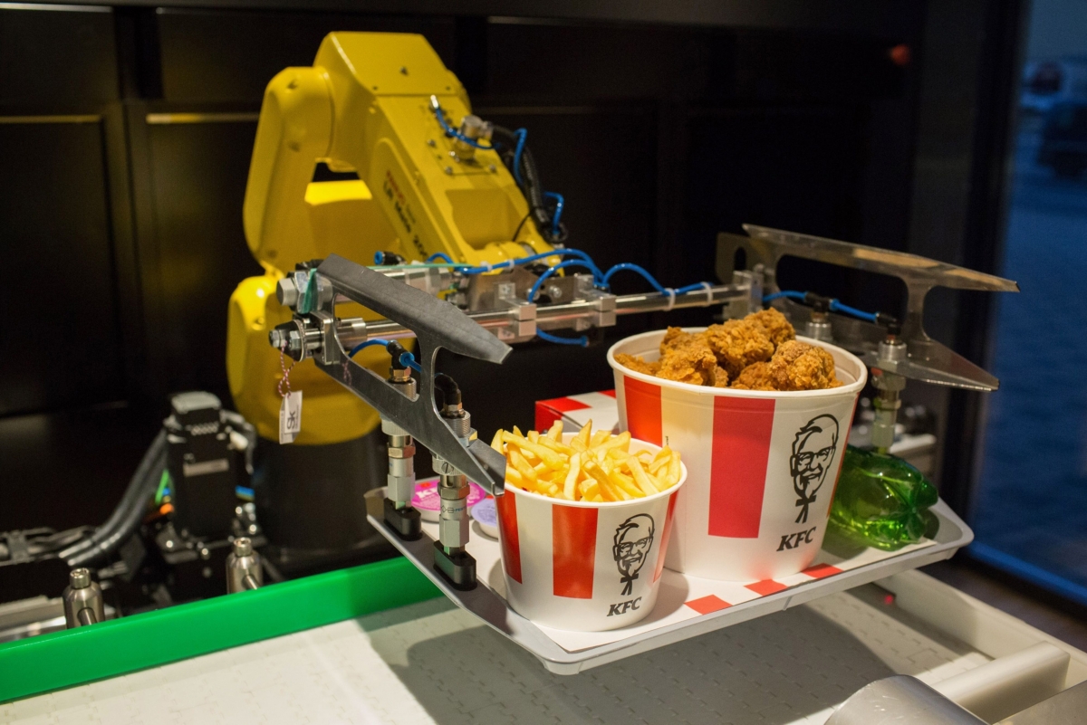A robotic arm lifts an order of food from a conveyor belt inside a new contactless Kentucky Fried Chicken restaurant in Moscow, Russia, on June 12. MUST CREDIT: Bloomberg photo by Andrey Rudakov