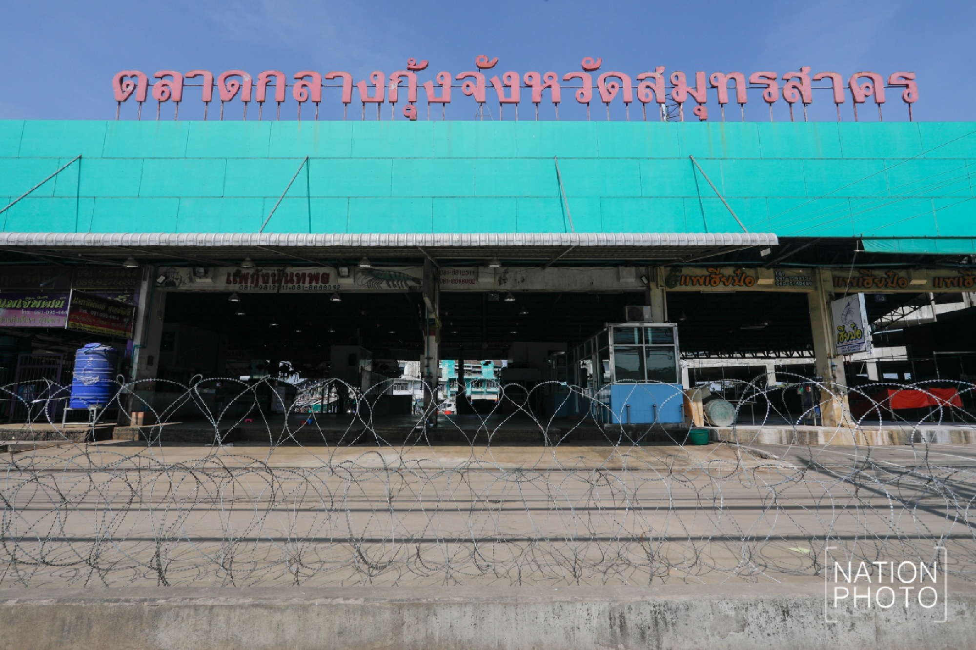 Police officers enclosed barbed wire around the shrimp market in Samut Sakhon province as a territory for COVID-19 quarantine while proactive screening continues.