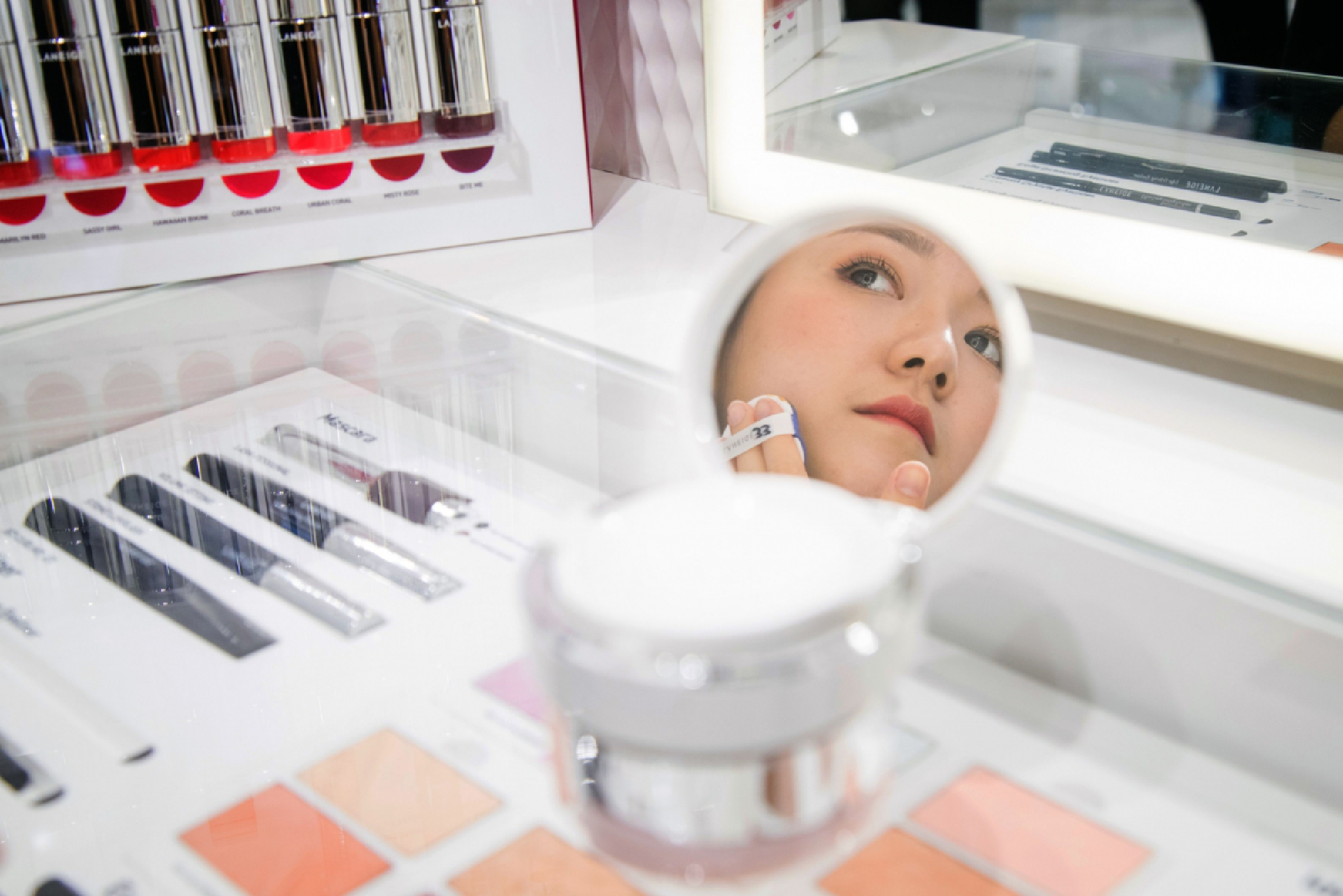 A store employee applies a foundation in a Laneige sore in Singapore on Sept. 12, 2017. The pandemic has taken a double hit on K-beauty, with social distancing and remote work lessening demand for makeup, and travel restrictions cutting off big-spending Chinese tourists. MUST CREDIT: Bloomberg photo by Nicky Loh