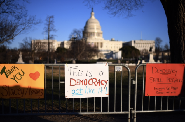 Pro-democracy signs line a fence near the U.S. Capitol in Washington on Jan. 9, three days after the building was invaded and vandalized by Trump-supporting rioters. MUST CREDIT: Photo for the Washington Post by Astrid Riecken