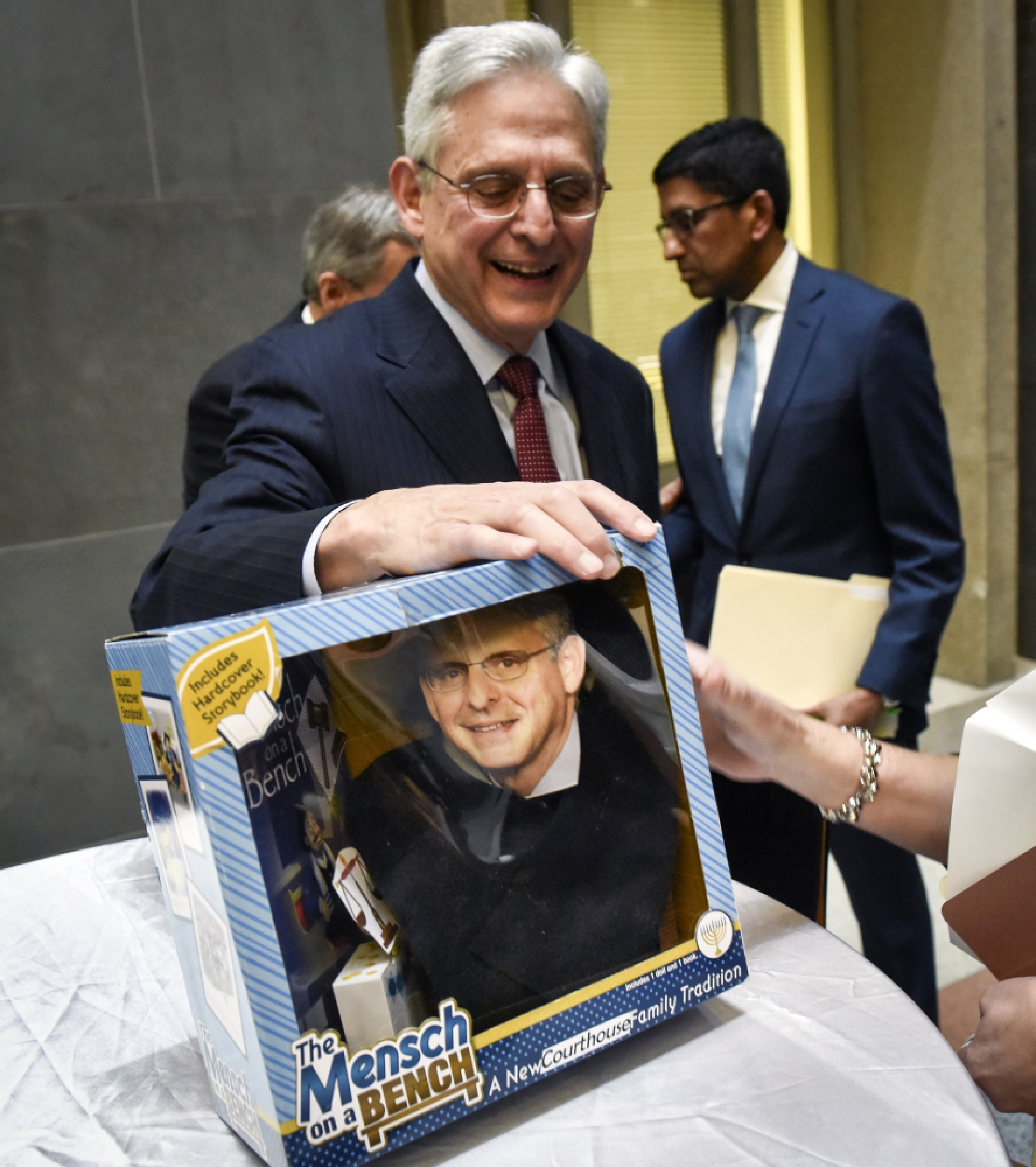 Judge Merrick Garland studies a toy that has been customized with his likeness, during a February, 2020 ceremony to pass the title of chief judge of the U.S. Court of Appeals for the D.C. Circuit to Sri Srinivasan, back right. MUST CREDIT: Washington Post photo by Bill O'Leary.