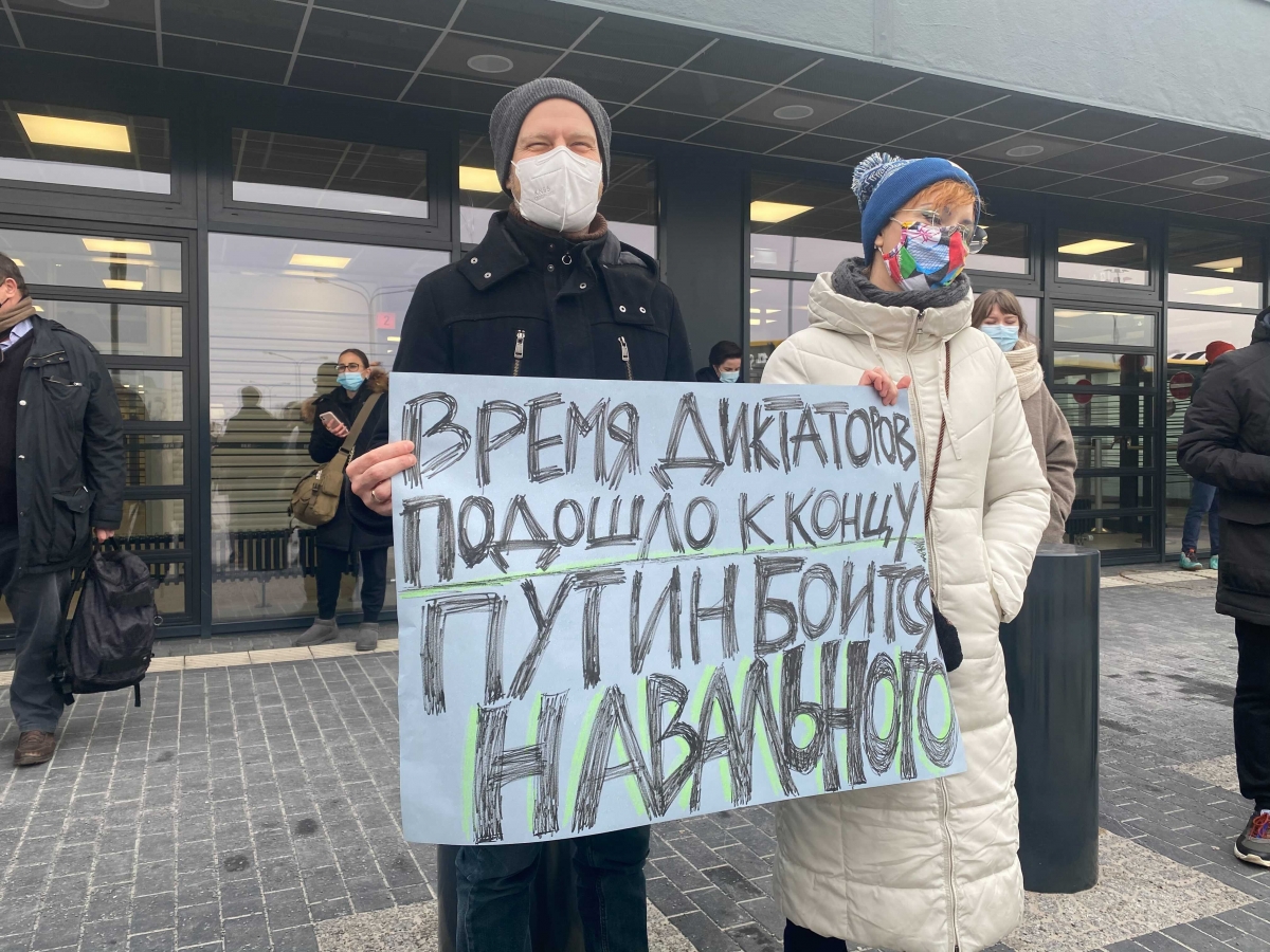 Ekaterina Raykova-Merz and Andreas Merz-Raykov wait outside Berlin airport Terminal 5 for Navalny to arrive. Their sign reads "The time of dictators has come to an end. Putin is afraid of Navalny." MUST CREDIT: Washington Post photo by Loveday Morris
