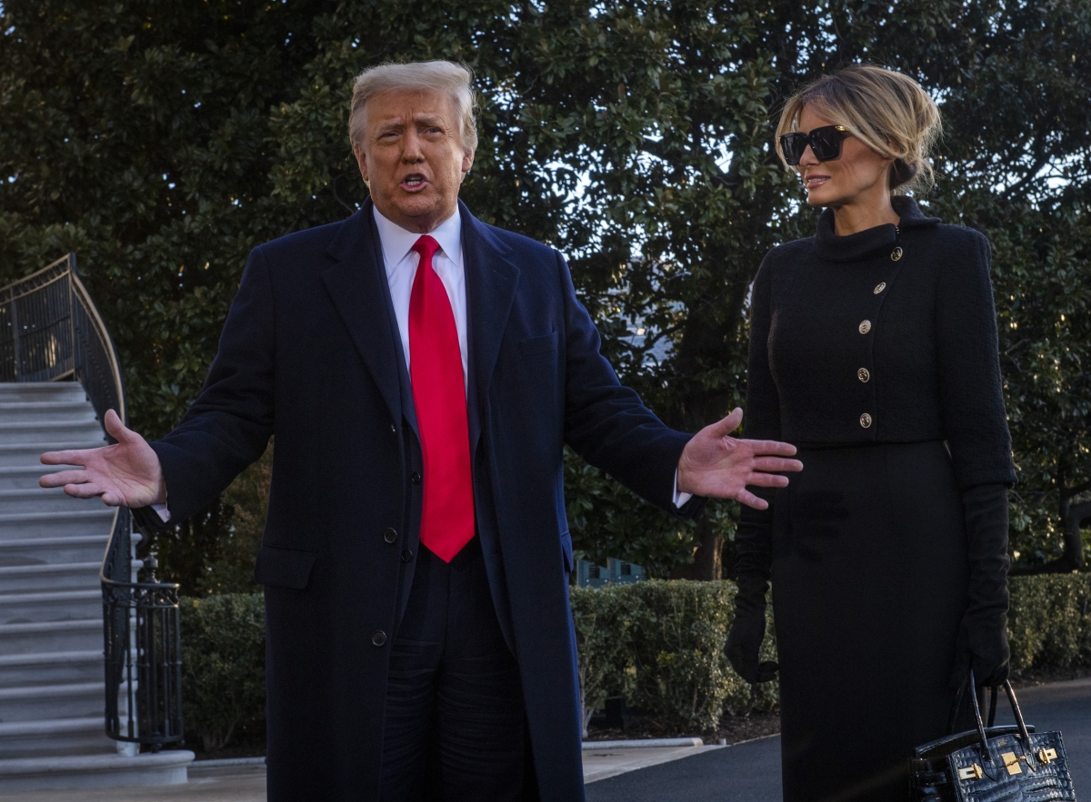 President Donald Trump, left, and first lady Melania Trump stop to speak to the news media as they depart the White House for the last time on Wednesday, Jan. 20 2021. MUST CREDIT: Washington Post photo by Bill O'Leary