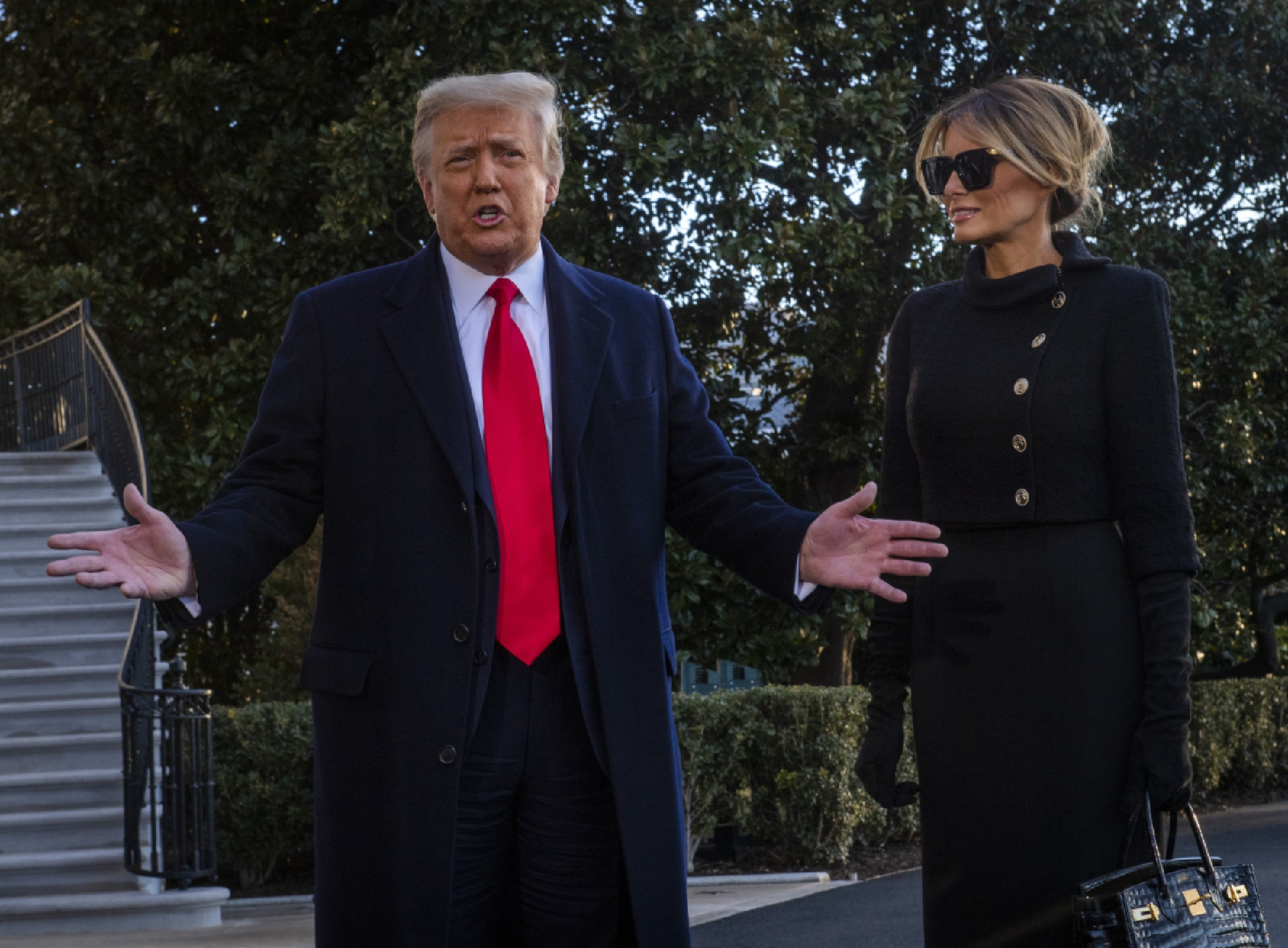 President Donald Trump, left, and first lady Melania Trump stop to speak to the news media as they depart the White House for the last time on Wednesday, Jan. 20 2021. MUST CREDIT: Washington Post photo by Bill O'Leary