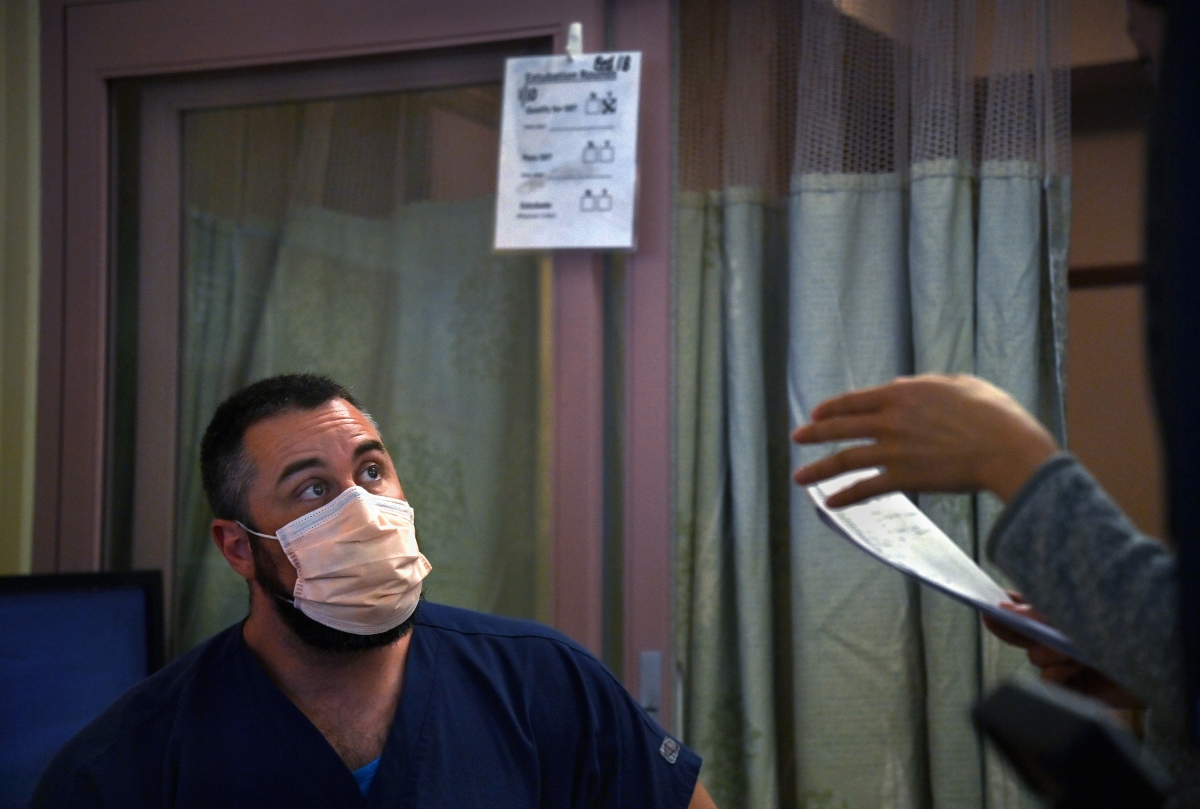 Dr. Brad Butcher chats with a nurse regarding the condition of a patient while doing rounds at UPMC Mercy Hospital in Pittsburgh on Jan. 11. MUST CREDIT: Washington Post photo by Michael S. Williamson.