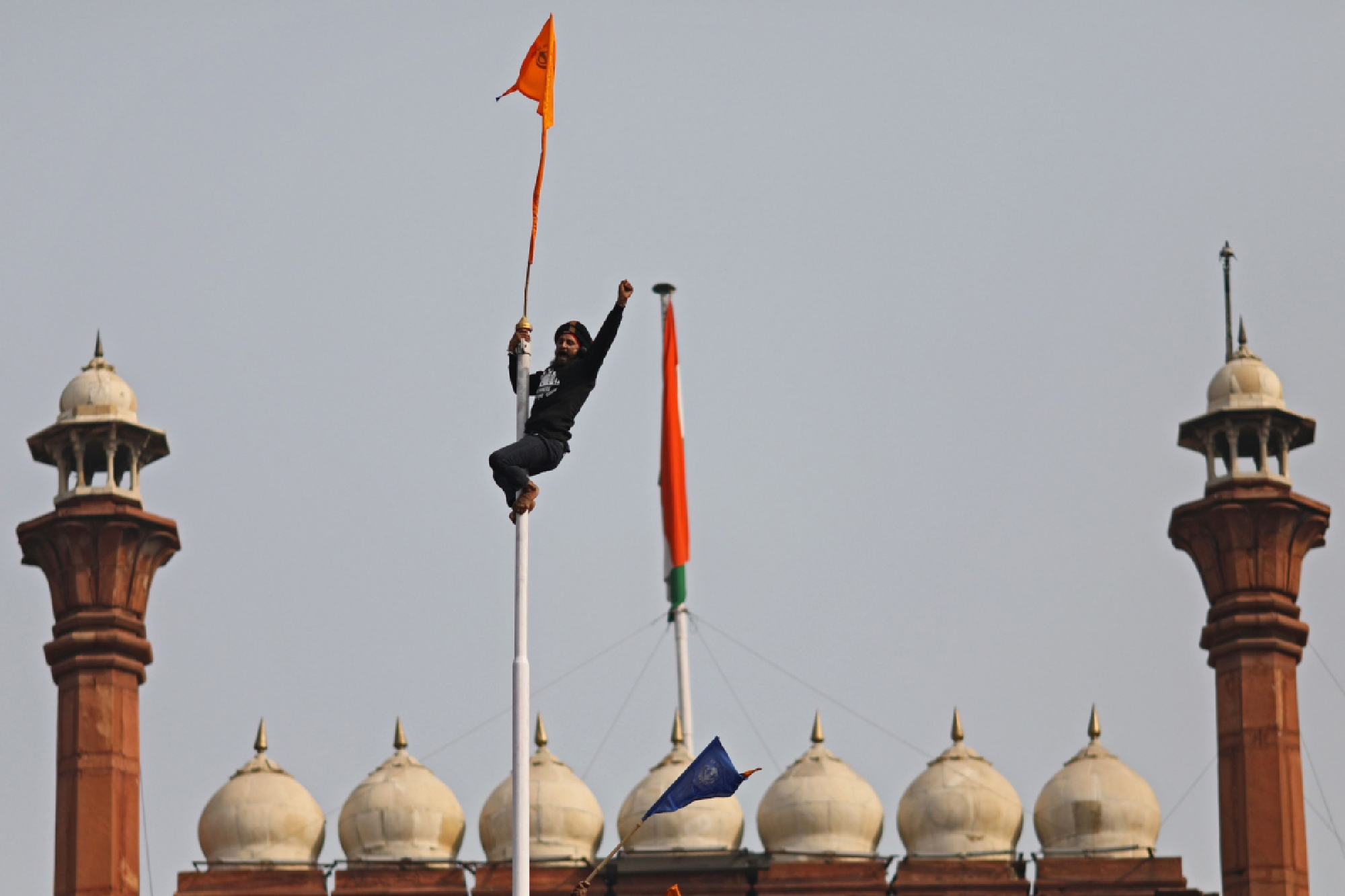 A farmer ascends a flagpole at the Red Fort during a protest in New Delhi on Jan. 26, 2021. Bloomberg photo by Anindito Mukherjee