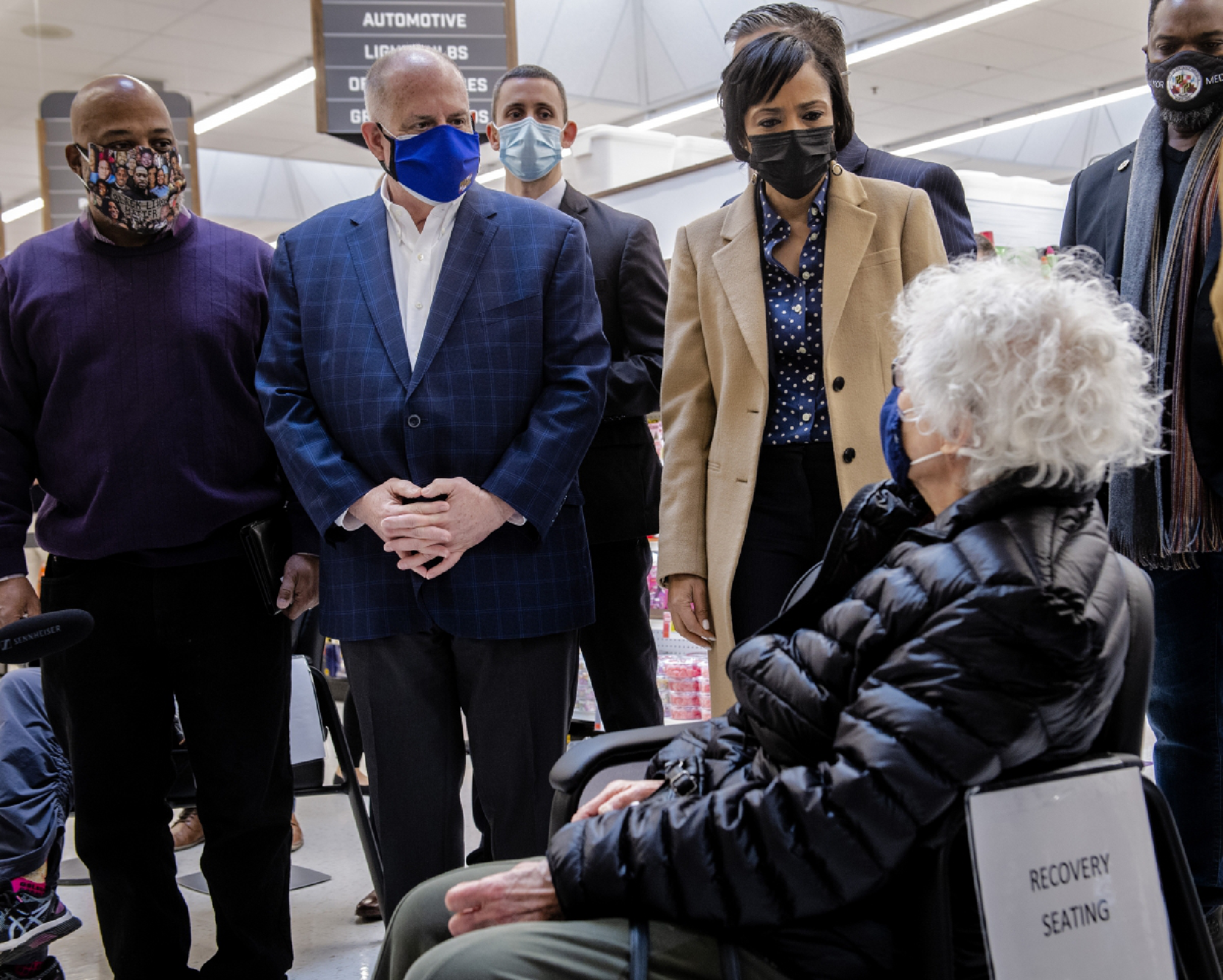 Maryland Gov. Larry Hogan, a Republican, left, Prince George's County Executive Angela Alsobrooks, a Democrat, and other officials talk with Louse Schmeltzer, who has just received her vaccine at a grocery store in Capitol Heights, Md., on Wednesday, Jan. 27, 2021. MUST CREDIT: Washington Post photo by Bill O'Leary