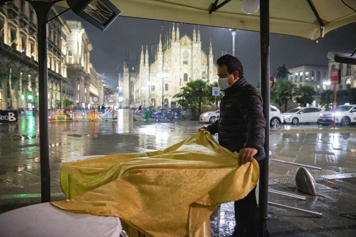 A worker prepares to close a restaurant before curfew in Duomo Square in Milan on Oct. 26, 2020. Each of the four Milanese fashion weeks has brought in about 30 million euros in tourism spending, a number that this year will be reduced about 80%, says the head of the Italian Fashion Chamber. MUST CREDIT: Bloomberg photo by Francesca Volpi