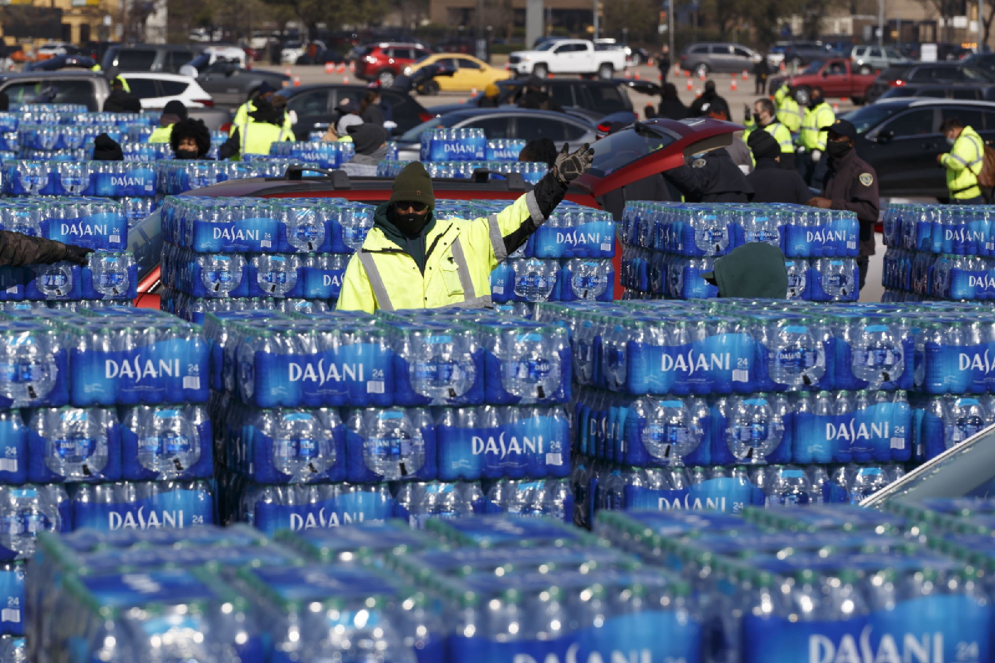  Houston city workers direct lines of cars waiting to receive bottled water at a high school sports complex. Houston, the nation's fourth-largest city, was under a boil-water advisory Friday, as more than 14 million Texans were still experiencing water-service disruptions. Photo by Michael Stravato for The Washington Post 