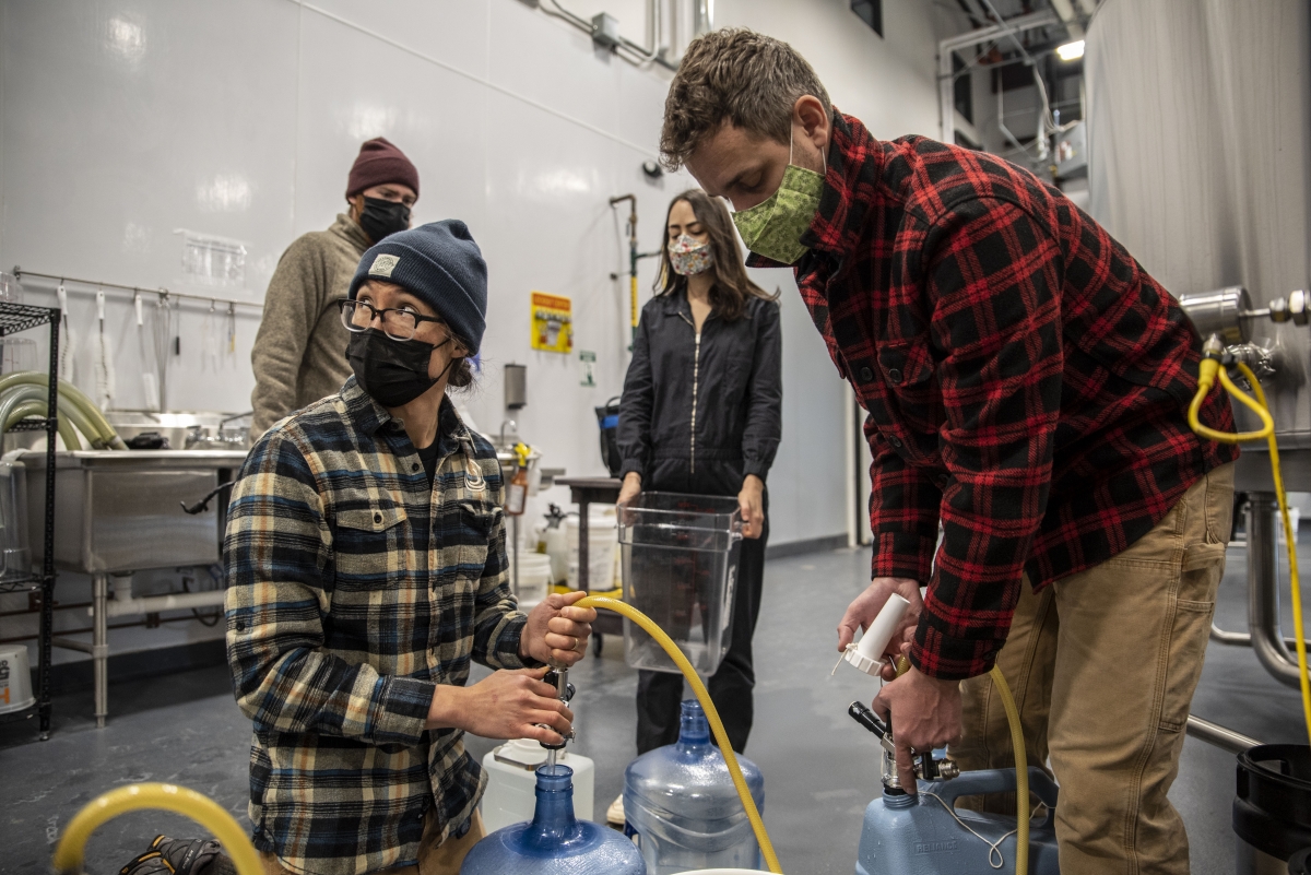 Will Jaquiss and Nao Ohdera fill containers with water for residents at Meanwhile Brewing Co. in Austin on Friday. Photo by Sergio Flores for The Washington Post