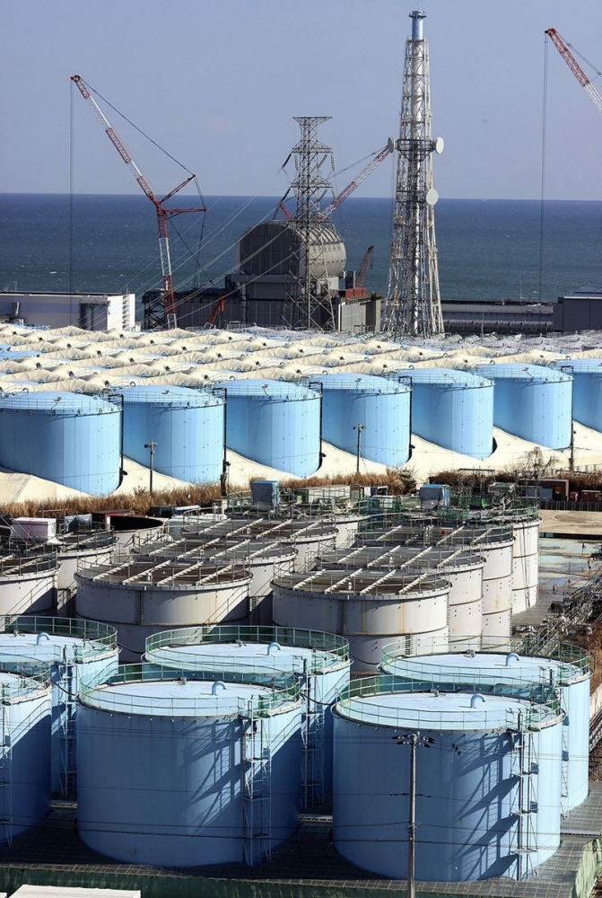 Rows of storage tanks holding treated but still contaminated water stand near the Fukushima Daiichi nuclear plant's No. 3 reactor building on Feb. 4, 2021. MUST CREDIT: Japan News/Yomiuri.