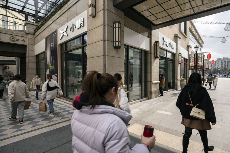 Shoppers pass the XPeng Inc. showroom at the Chamtime Plaza in Shanghai on March 8, 2021. MUST CREDIT: Bloomberg photo by Qilai Shen