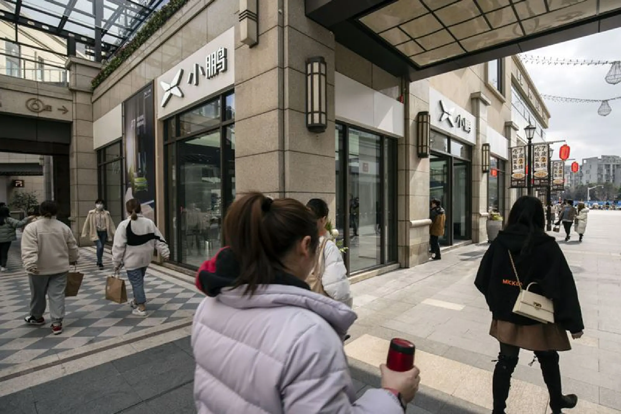 Shoppers pass the XPeng Inc. showroom at the Chamtime Plaza in Shanghai on March 8, 2021. MUST CREDIT: Bloomberg photo by Qilai Shen