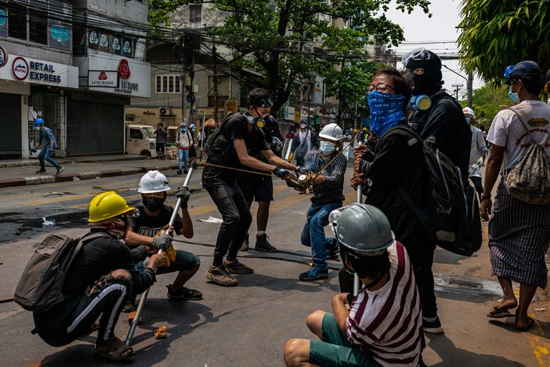 Protesters throw a homemade smoke bomb toward security forces. Sanchaung residents have offered assistance and shelter to anti-coup demonstrators. MUST CREDIT: photo for The Washington Post.