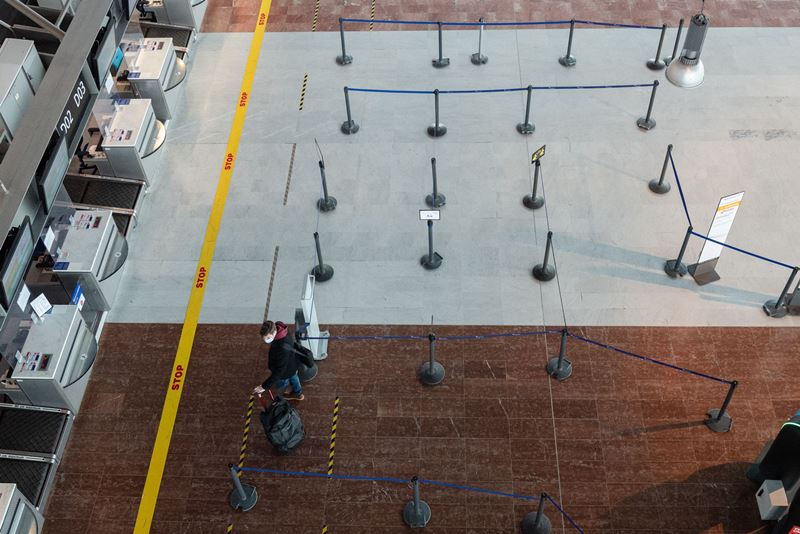 A lone passenger waits by the check-in counters at Nice Cote d'Azur Airport in Nice, France, on Feb. 5, 2021. MUST CREDIT: Bloomberg photo by Jeremy Suyker.