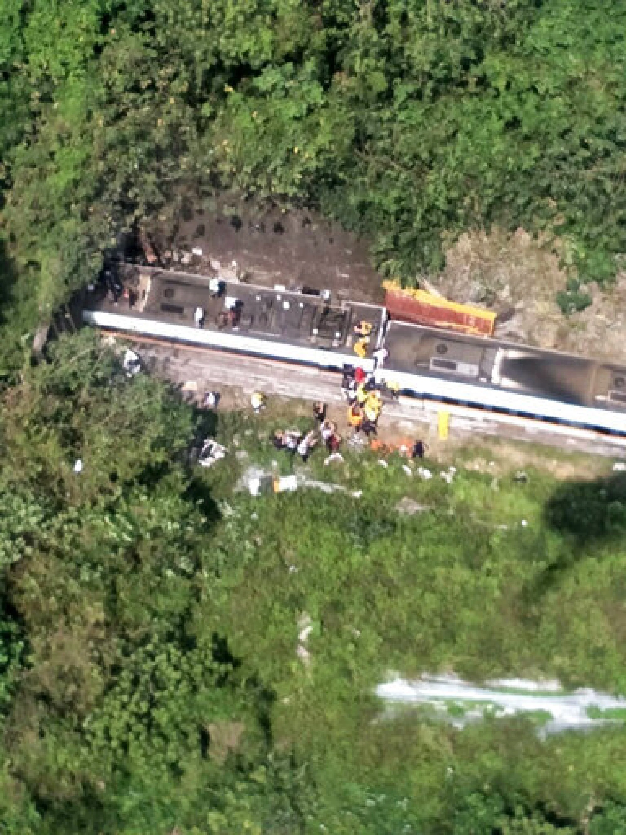 In this photo released by National Fire Agency, rescue workers are seen near the site of a partial train derailment in Toroko Gorge in Taiwan’s eastern Hualien region, Friday, April 2, 2021. The train partially derailed along Taiwan’s east coast Friday, injuring an unknown number of passengers and causing potential fatalities. (National Fire Agency Department via AP)